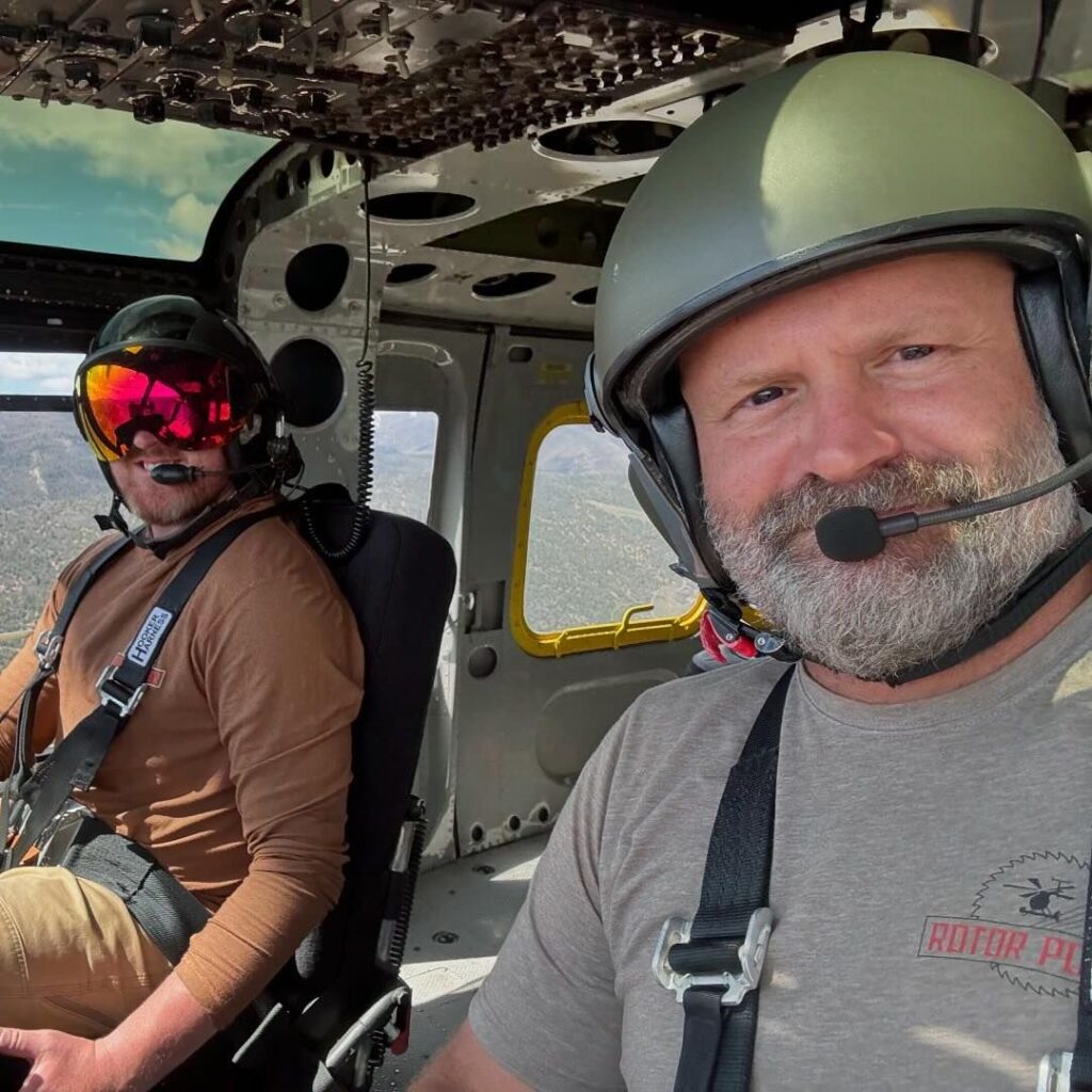 Two utility helicopter pilots seated in the cockpit during flight.